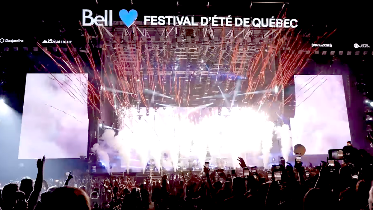 La scène illuminée du Festival d'été de Québec et la foule en soirée.