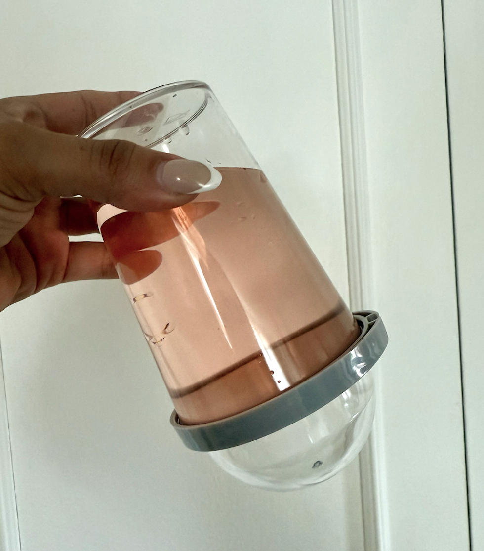 La tasse du Dollarama, \u00e0 l'envers, avec du liquide \u00e0 l'int\u00e9rieur.