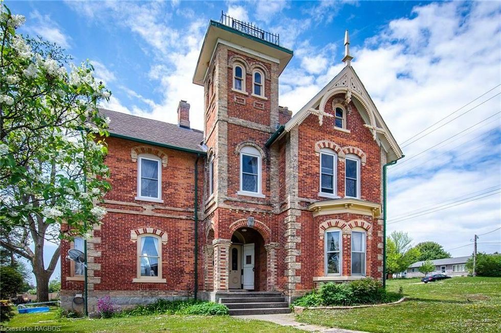 Large home for sale with a tower.