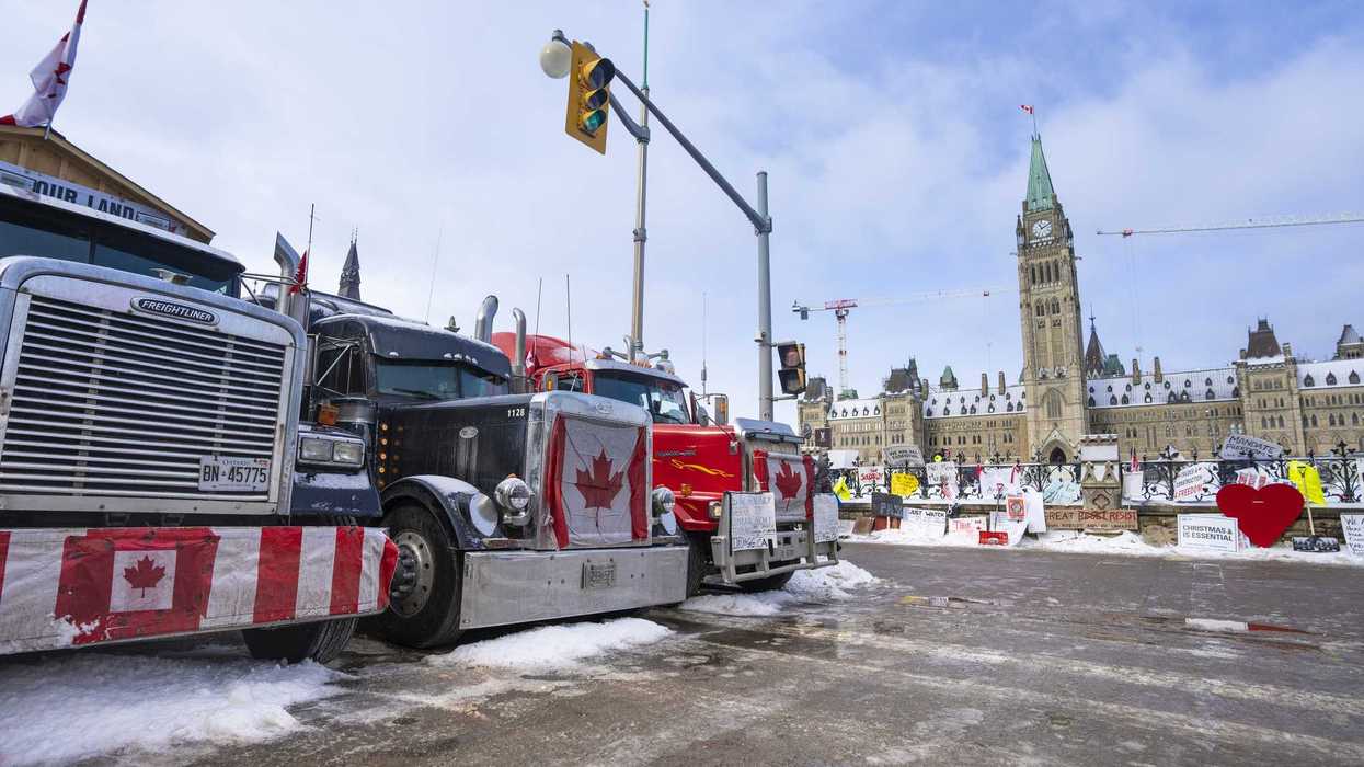 Large trucks parked in the middle of Wellington Street in front of Parliament Hill in Ottawa.