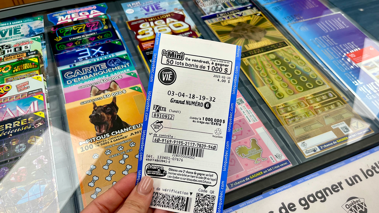 Le billet de loterie Grande Vie tenu dans une main.