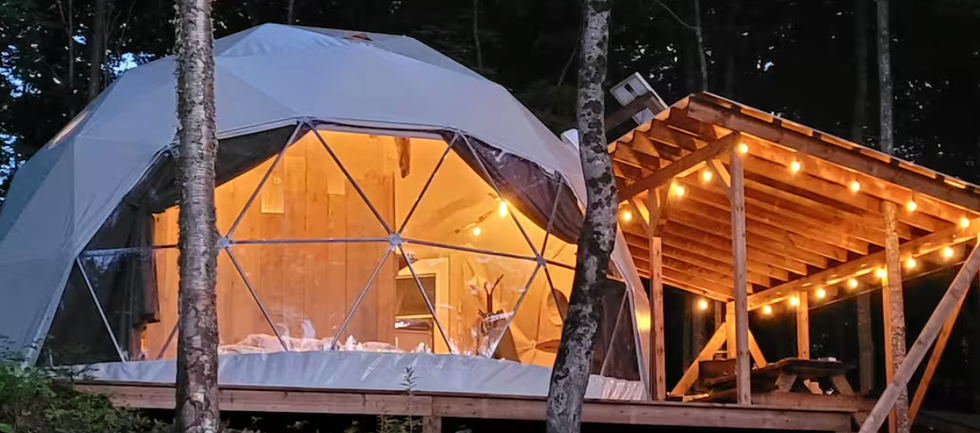 Le D\u00f4me La Hutte avec sa terrasse illumin\u00e9e \u00e0 Brownsburg au Qu\u00e9bec.