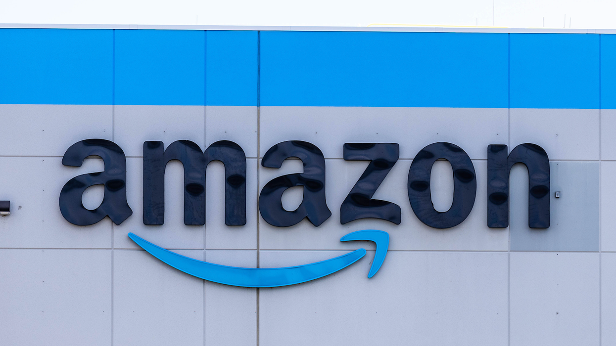 Le logo d'Amazon sur un édifice gris et bleu.