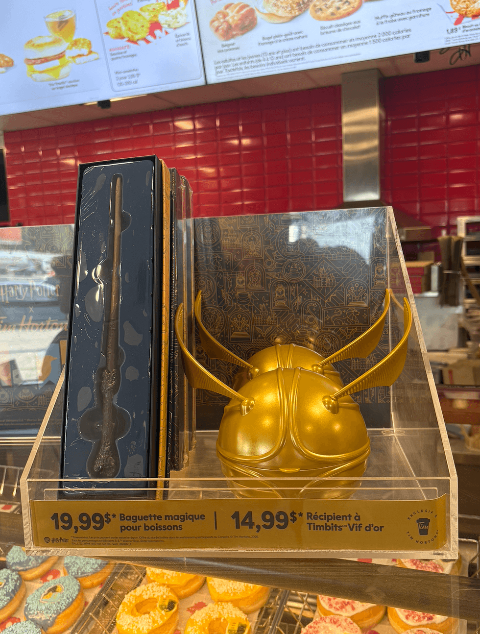 Le porte-Timbits Vif d'or et la \u00ab baguette pour boissons \u00bb de Harry Potter sur le comptoir du Tim Hortons.
