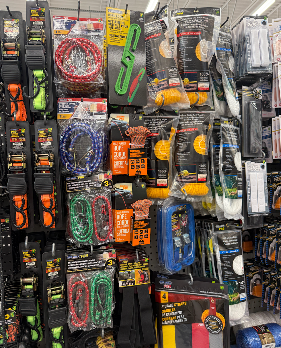 Le pr\u00e9sentoir du Dollarama rempli de cordes, crochets, sangles et tendeurs multicolores.