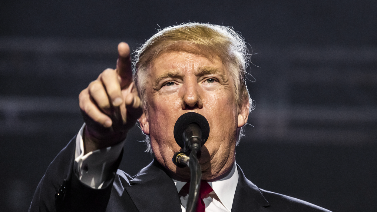 Le président élu des États-Unis, Donald Trump, pointe du doigt quelque chose en parlant au micro.