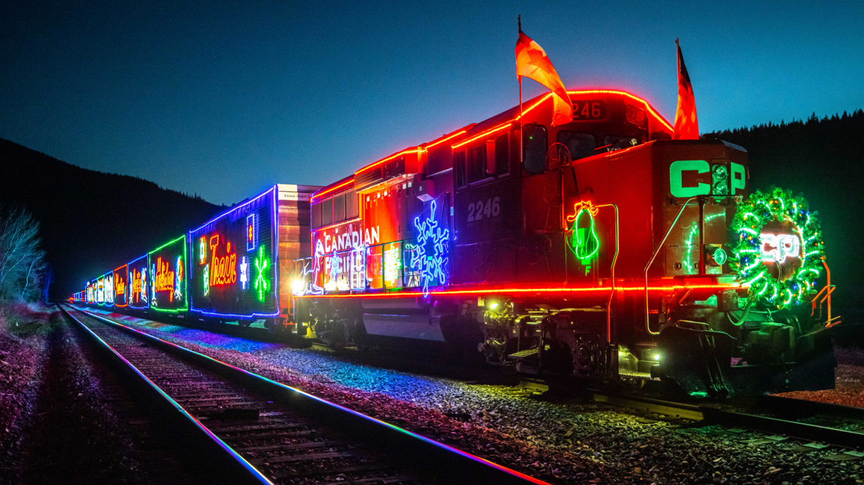 Le train de Noël du Canadian Pacifique tout illuminé qui circule sur les rails.