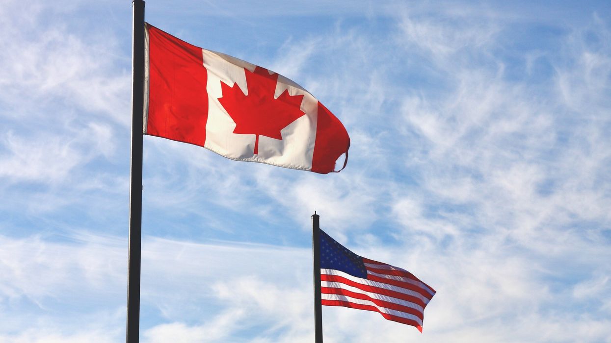 Les drapeaux canadien et américain dans le vent.