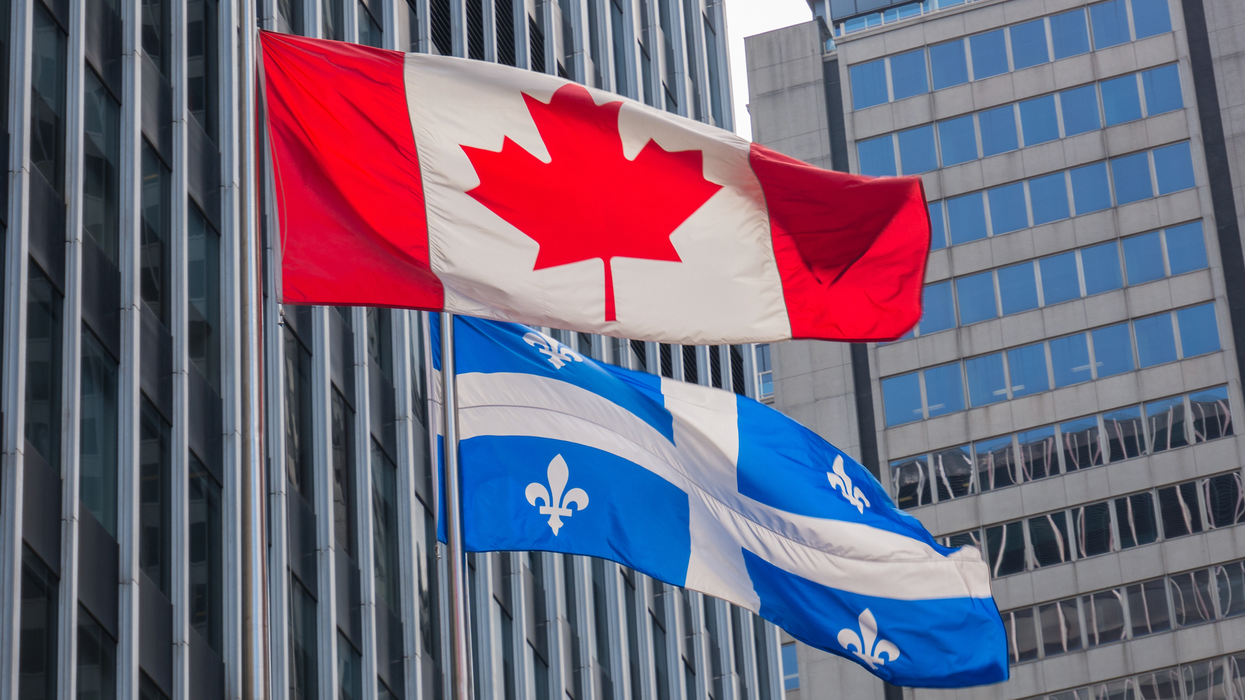 Les drapeaux du Canada et du Québec qui flottent dans le vent.