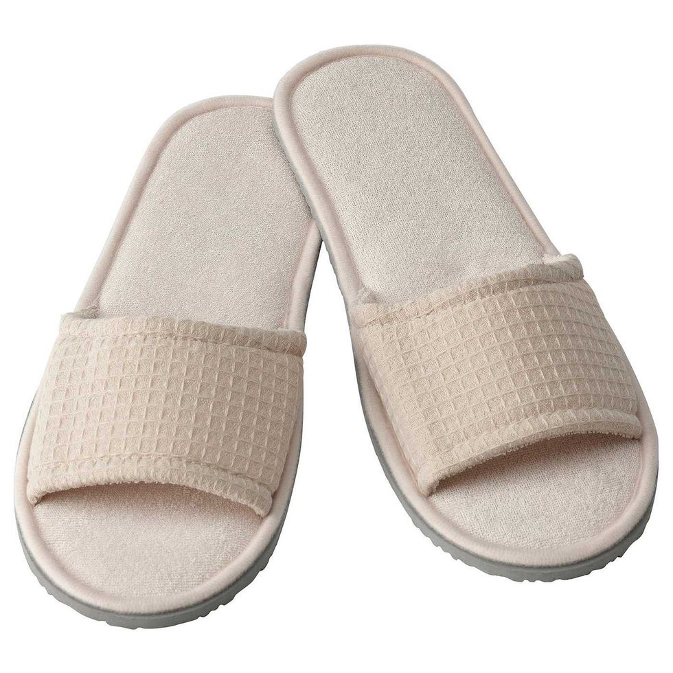 Les mules SKOVELSJ\u00d6N beiges d'IKEA sur fond blanc.