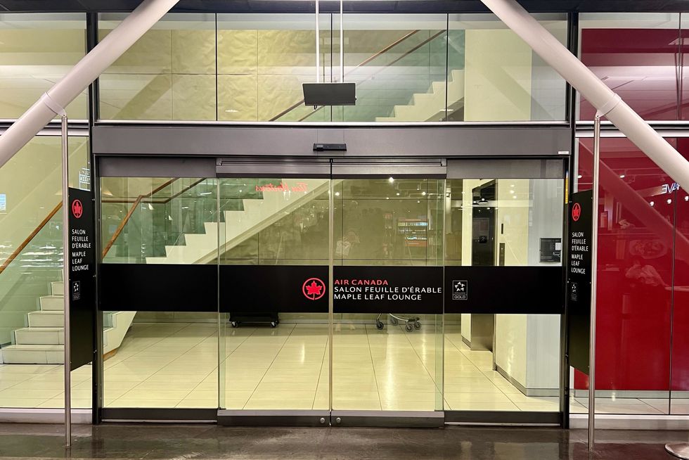 Les portes d'entr\u00e9e vitr\u00e9es du Salon Feuille d'\u00e9rable d'Air Canada dans la zone transfrontali\u00e8re de l'a\u00e9roport de Montr\u00e9al.