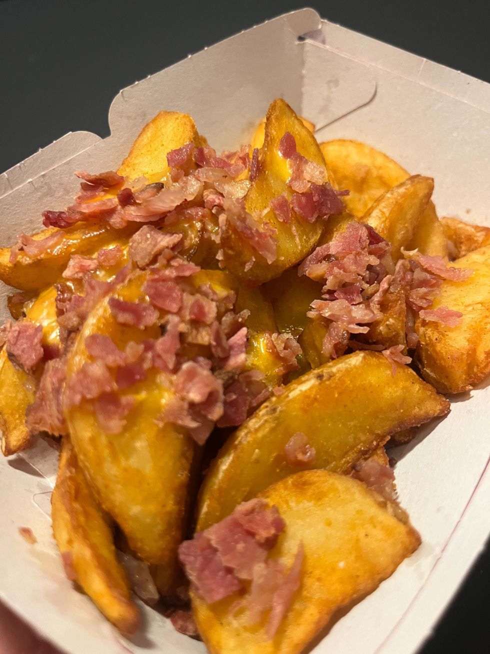 Les quartiers de pommes de terre garnies de bacon et sauce au fromage.