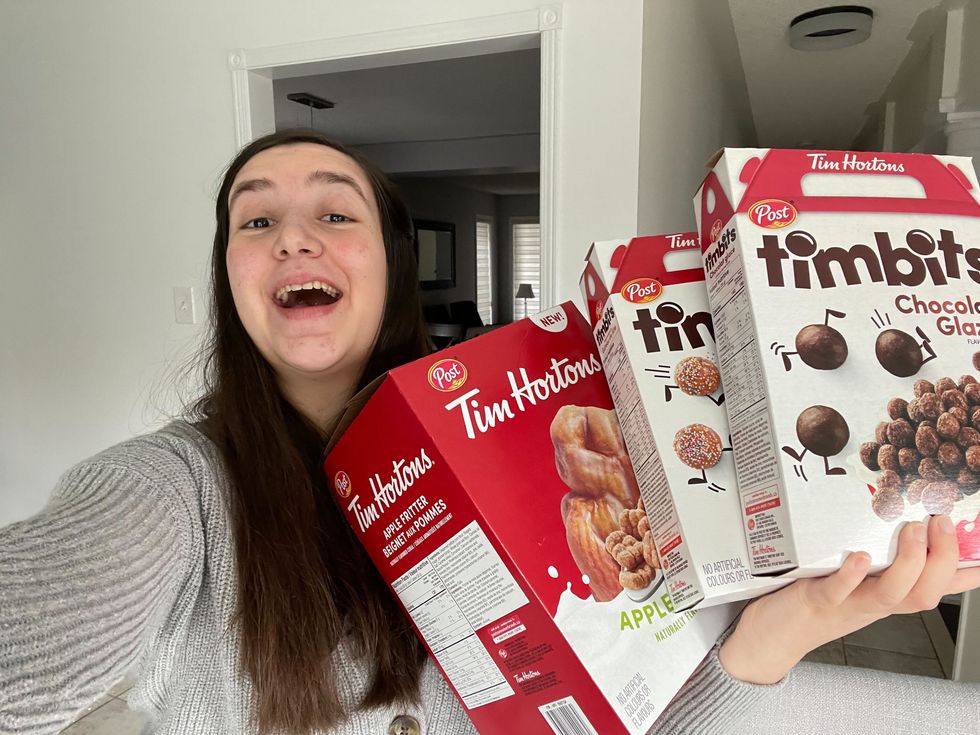 Lisa Belmonte holding boxes of Tim Hortons cereals.