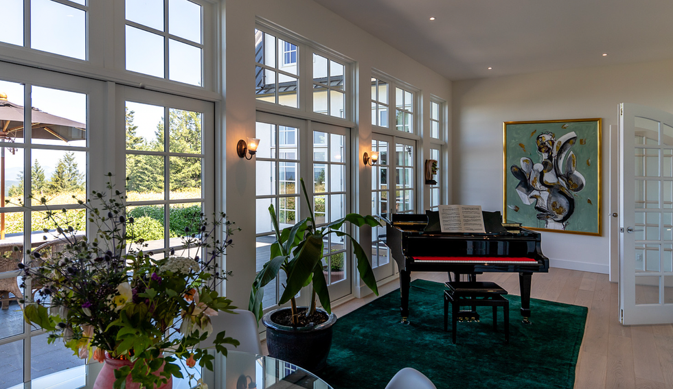 Living area, piano and floor-to-ceiling windows.