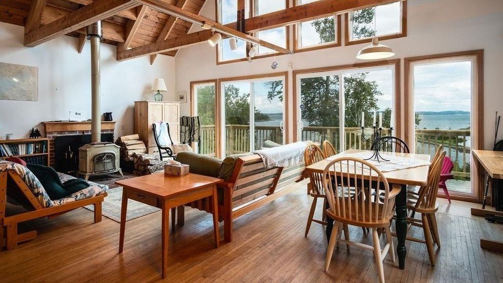Living room that has access to a wraparound deck and views of the lake.