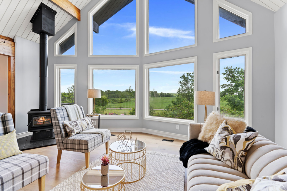 Living room with a wood stove and countryside views.
