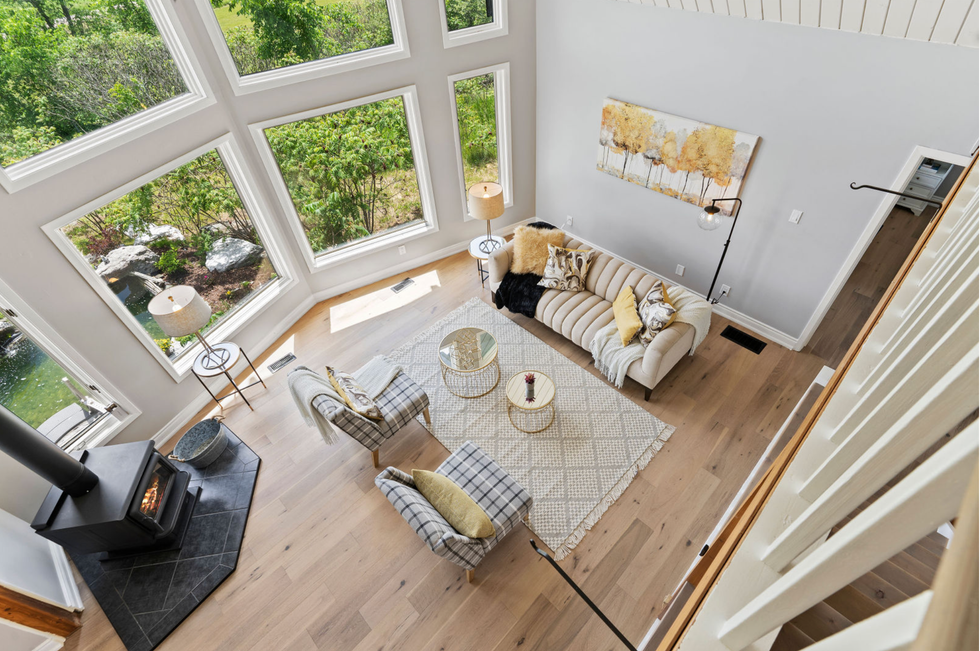Living room with a wood stove and countryside views.