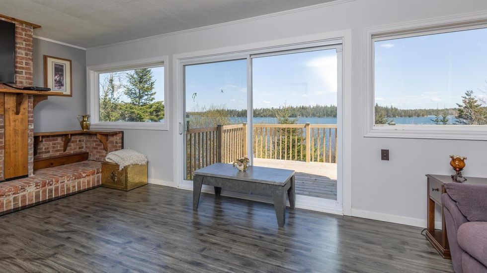 Living room with access to a deck that overlooks the ocean.