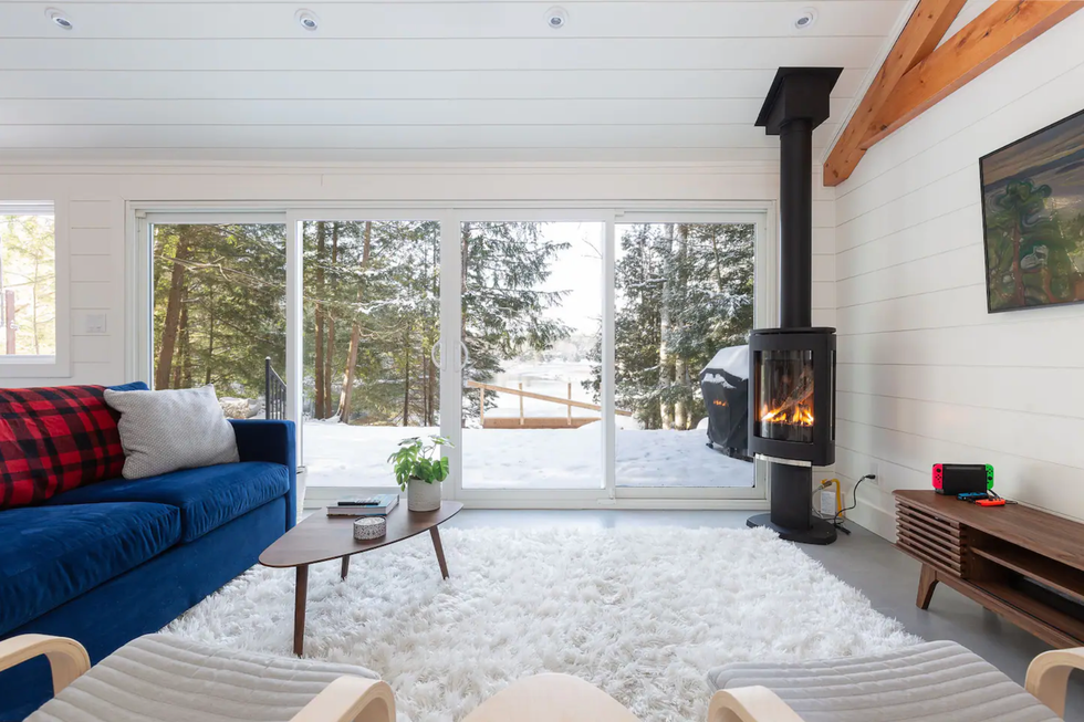 Living room with fireplace and snowy views.
