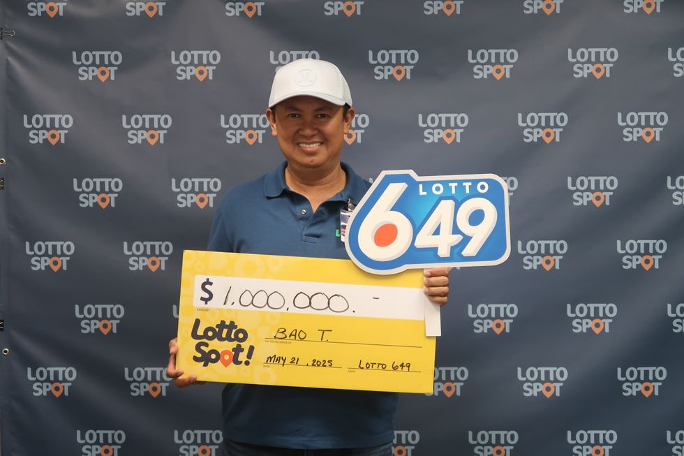 lotto 6/49 winner bao tran holding a cheque