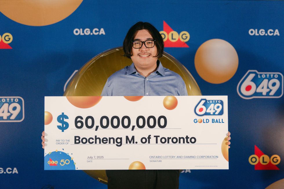 lotto 6/49 winner bochen mei holding a $60 million chrque