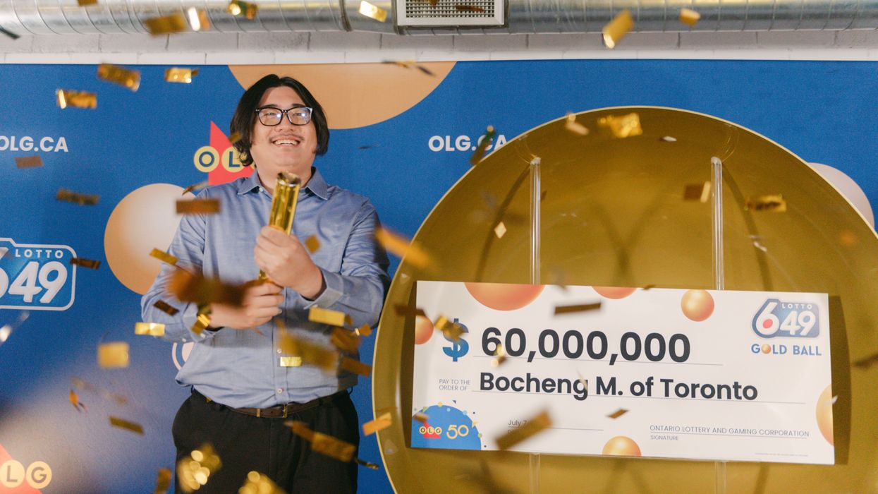 lotto 6/49 winner bochen mei setting off confetti next to a $60 million cheque