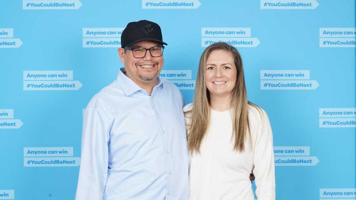 lotto 6/49 winners Rene L. and Brittany C. in front of a blue backdrop