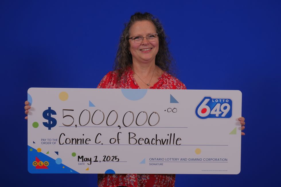 lotto 649 winner connie christie holding $5 million cheque from olg