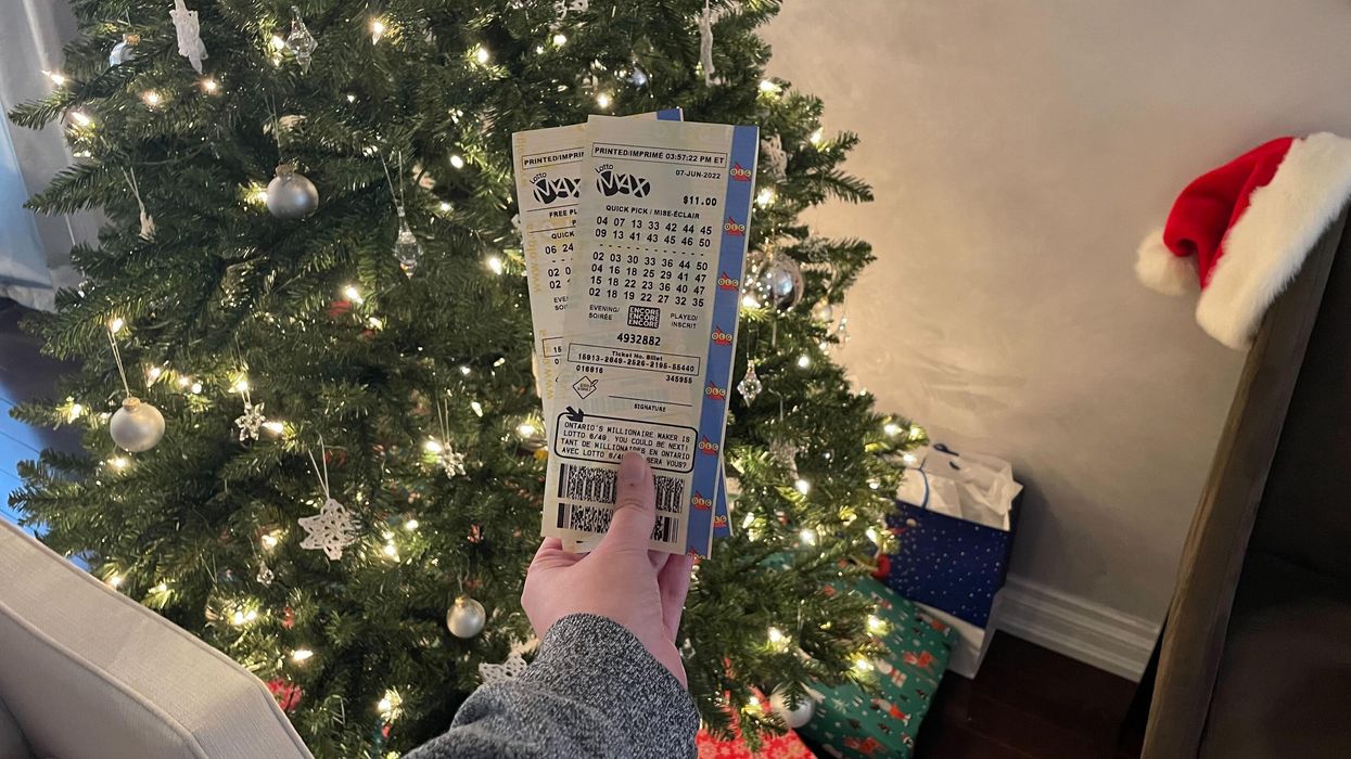 Lotto Max tickets in front of a Christmas tree.