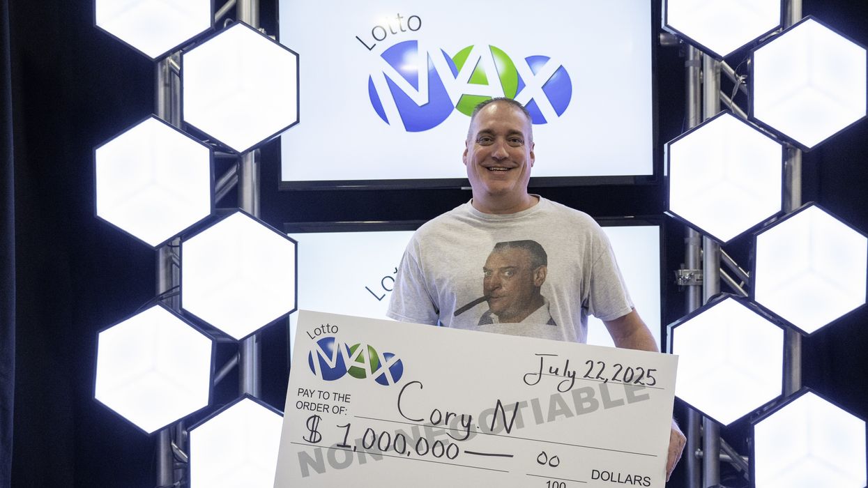 lotto max winner cory nickason holding a $1 million cheque