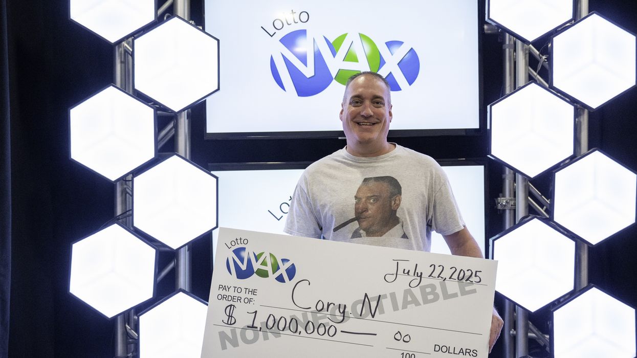 lotto max winner cory nickason holding a $1 million cheque