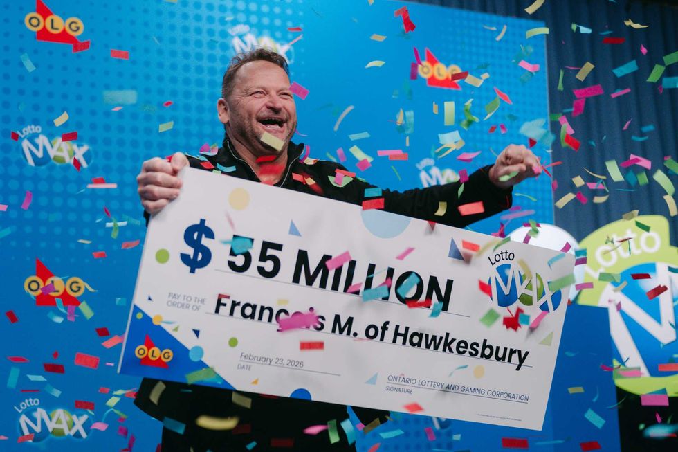 lotto max winner Francois Masse holding a $55 million cheuqe surrounded by confetti