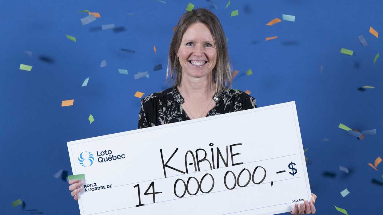 lotto max winner holding a $14 million cheque