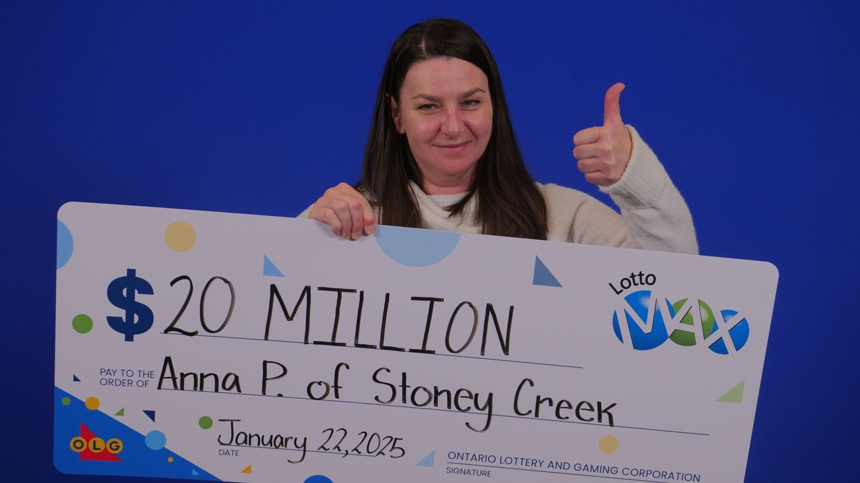 lotto max winner holding a $20 million cheque