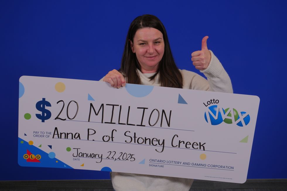 lotto max winner holding a $20 million cheque
