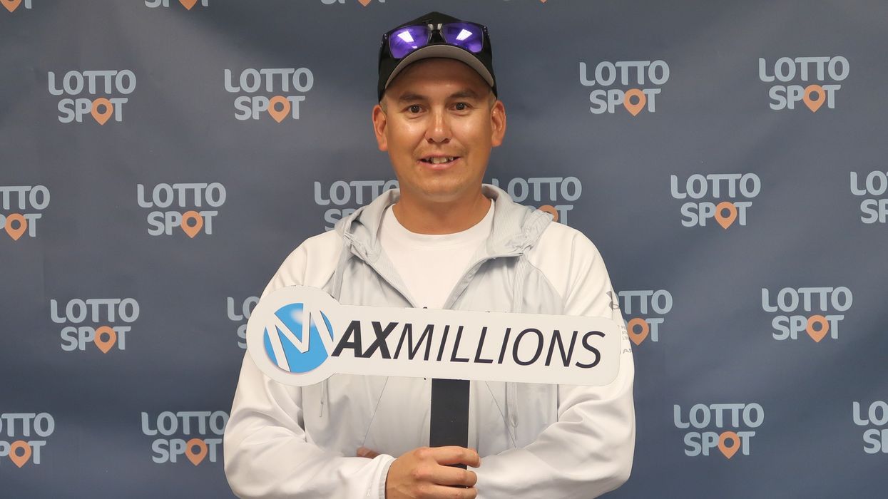 lotto max winner jack puglas holding a maxmillions sign