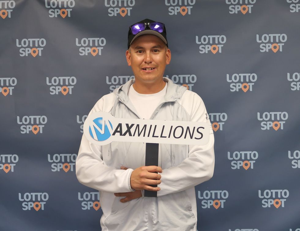 lotto max winner jack puglas with a maxmillions sign