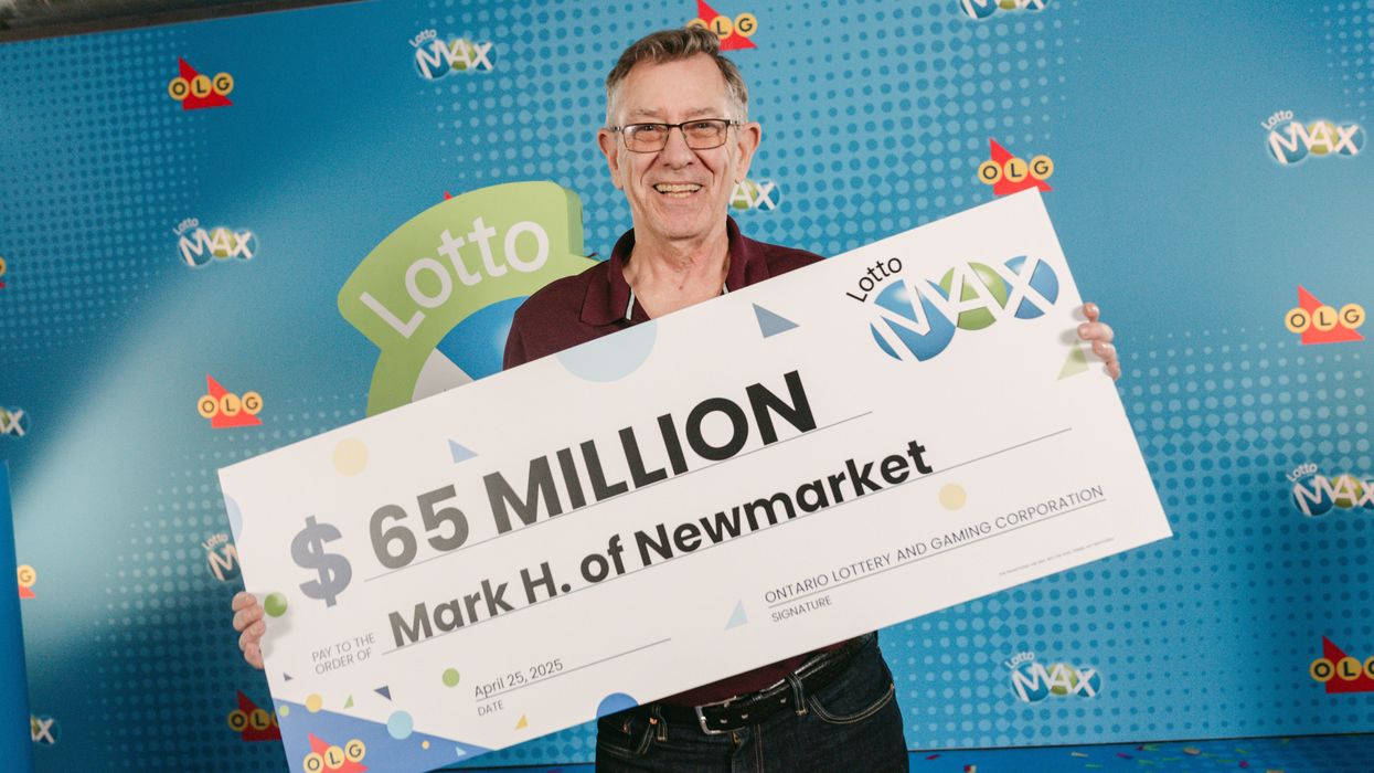 lotto max winner mark hanley holding a $65 million cheque