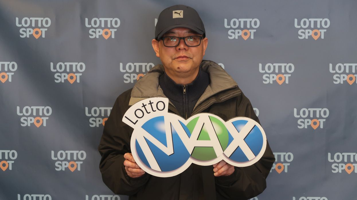 lotto max winner ming zhu holding a lotto max sign