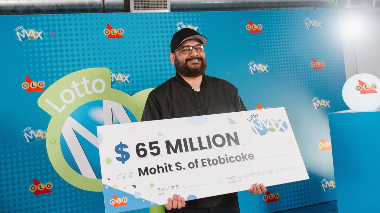 lotto max winner mohit sharma holding a $65 million cheque