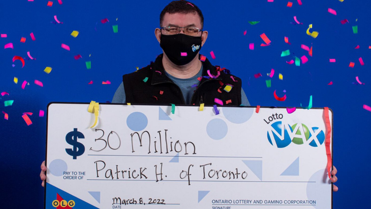 Lotto Max winner Patrick Hale holding his $30 million cheque.