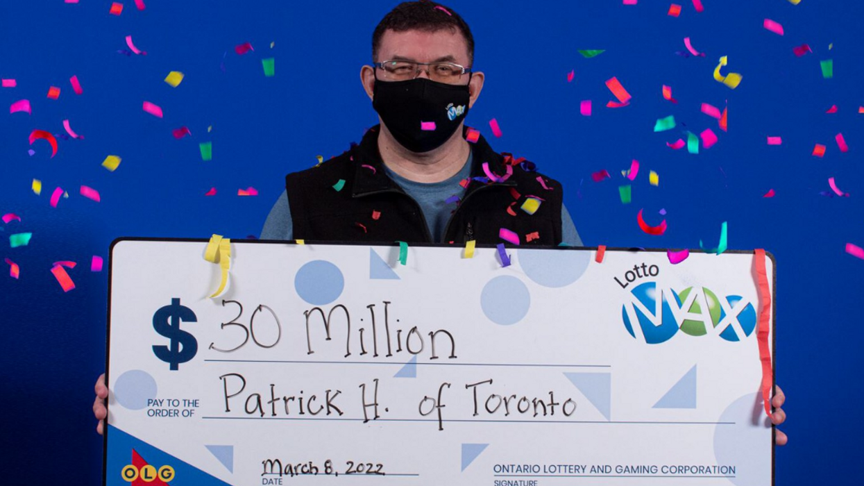 Lotto Max winner Patrick Hale holding his $30 million cheque.