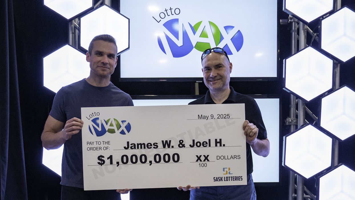 lotto max winners James Wawryk and Joel Hedlin holding a $1 million cheque