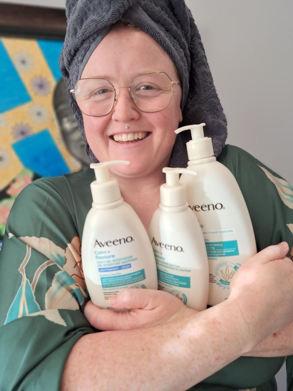 Louie Murray tenant les trois produits pour le corps Aveeno\u00ae Calm + Restore\u00ae dans ses bras.