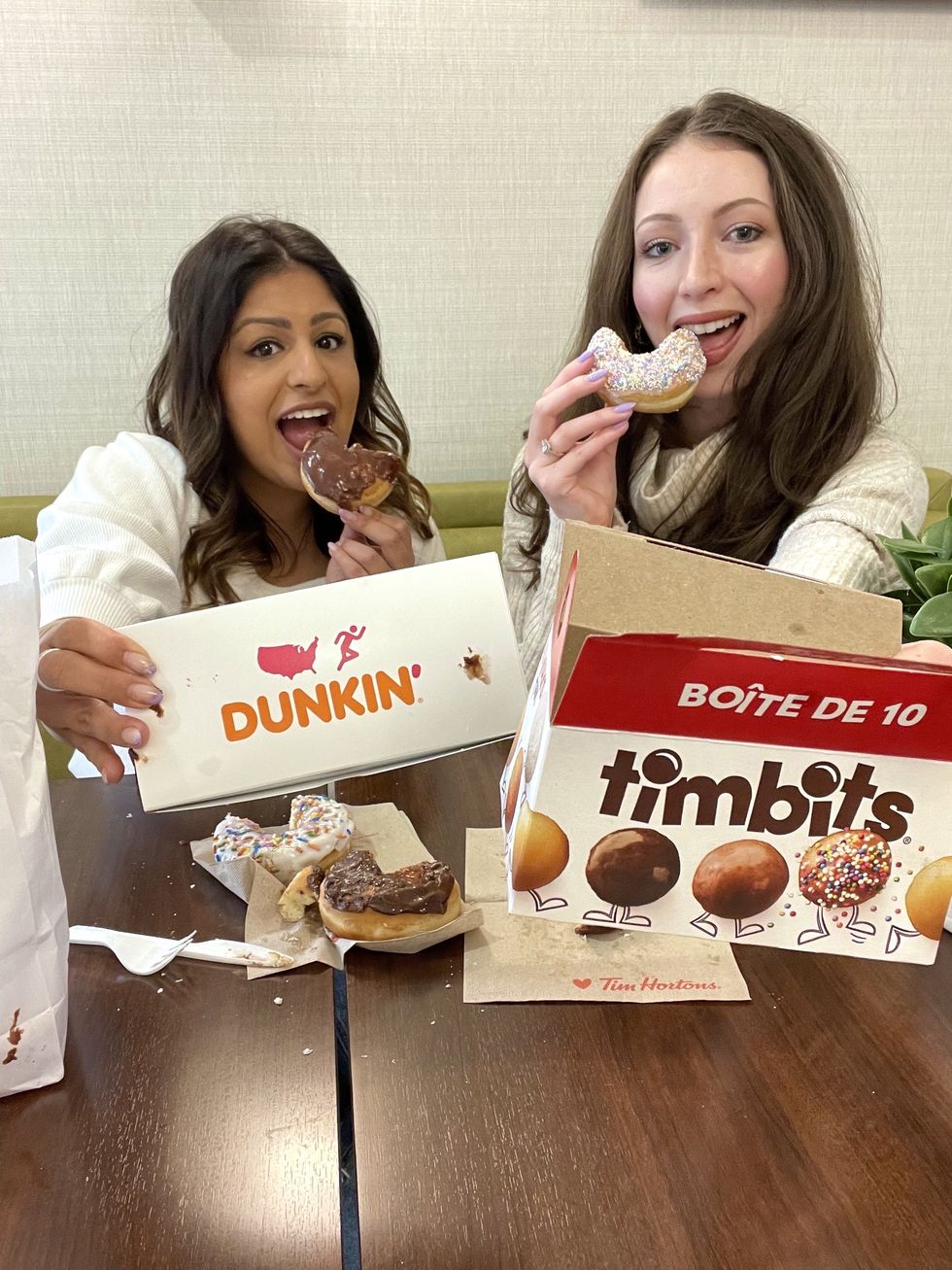 Madeline and Ashna with Dunkin' and Tim Hortons boxes.