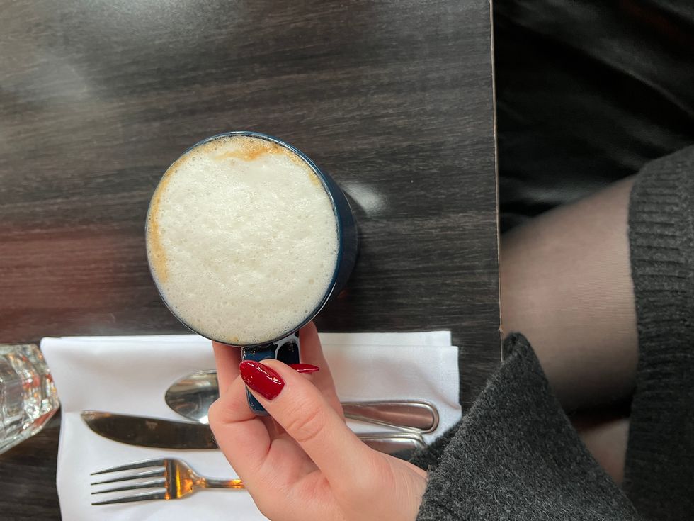 Madeline holding a cappuccino.