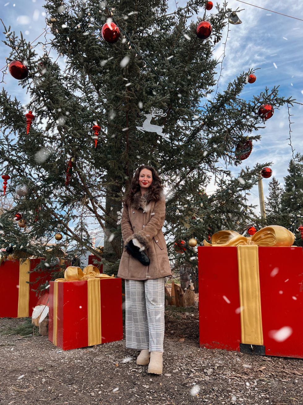 Madeline in front of a Christmas tree.