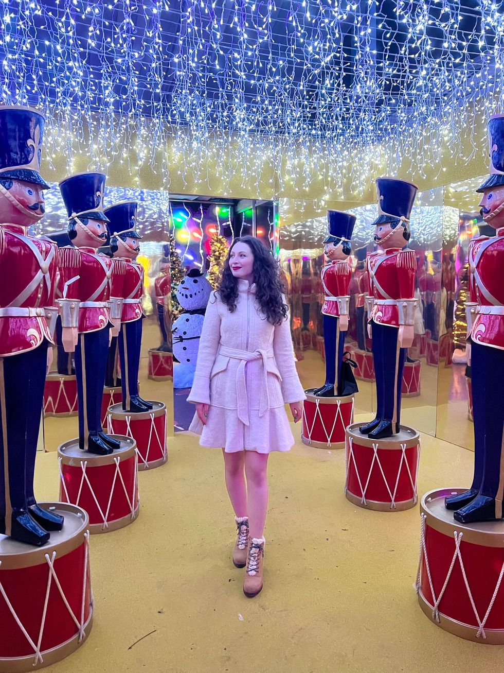 Madeline standing beside giant nutcrackers.
