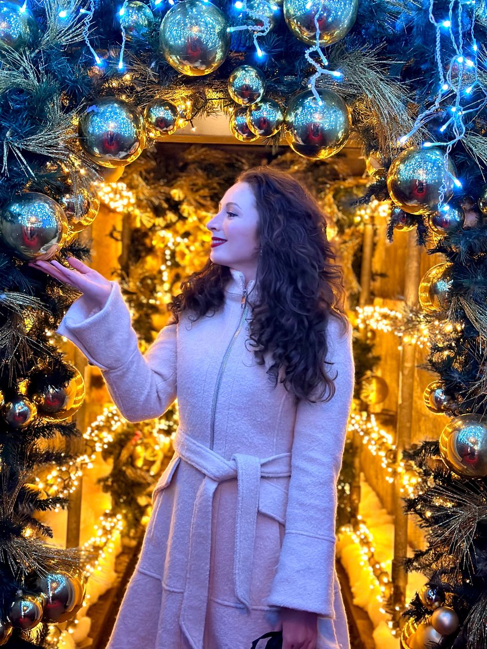 Madeline standing by Christmas decor.