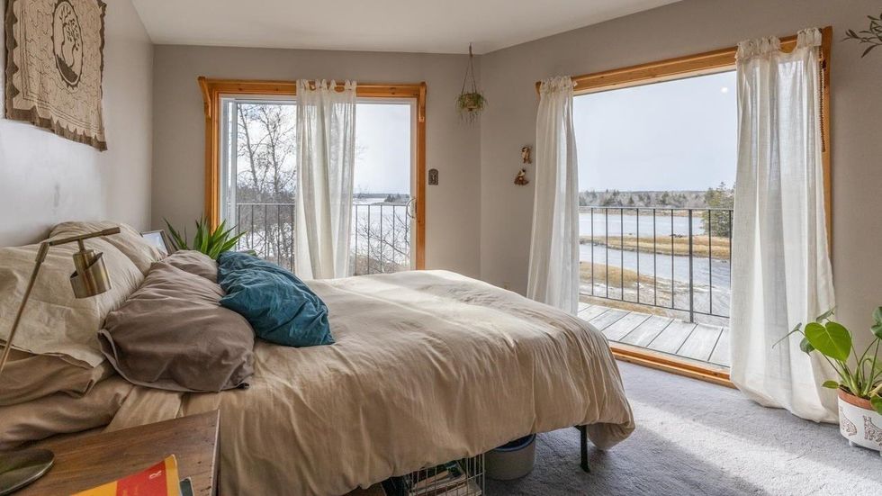 Main bedroom in the house with a wraparound balcony overlooking the water.